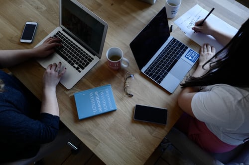 An image of two colleagues working together with a laptop